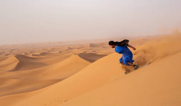 モロッコのエルグ チェガガの砂丘に乗ってトゥアレグ ガンドゥーラに乗ったサンドボーダーのサイドビュー — ストック写真
