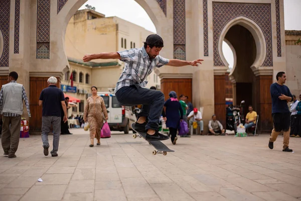 Şehir meydanında insanlar arasında atlama hile skateboarder sokak kıyafeti 