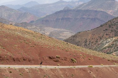 kaykaycı güneşli bir günde Orta Atlas dağları arasında yolda paten sürme, Fas 