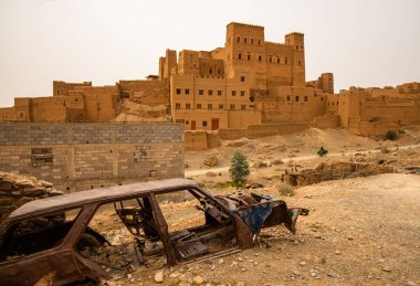 Eski geleneksel mimari ve paslı araba manzarası güneşli bir günde Arap şehrinde kalır