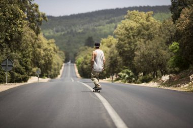 kaykaycı güneşli bir günde yolda paten sürme