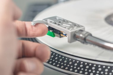 Turntable vinil kayıt çalar. Retro ses ekipmanları. Beyaz sınırlı vinil kaydı. Pikap üzerinde tonearm koyarak yakın çekim