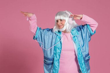 müzik ve pembe bir arka plan karşı atış stüdyo dans retro giysiler ile genç kadın