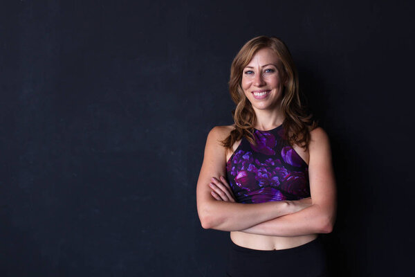 Portrait Confident Friendly Young Woman Smiling Her Arms Crossed Dark Stock Image
