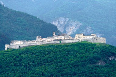 İtalya 'nın Trento ilindeki Adige vadisi boyunca uzanan ortaçağ kalesi Castel Beseno' nun manzarası, bisiklet yolundan görüldü.