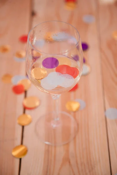 Festa sobre fundo copo de vinho vazio confetti — Fotografia de Stock
