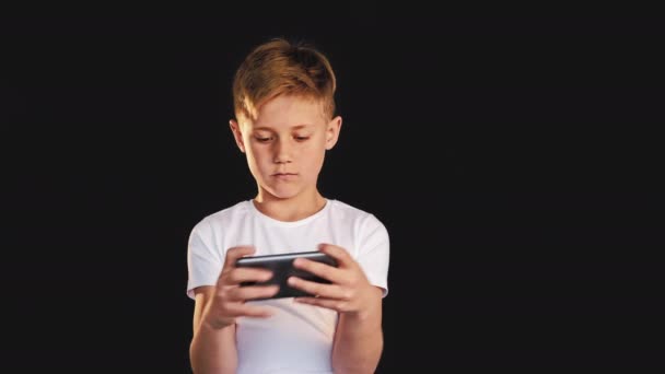 Εθισμός κινητό παιχνίδι νεαρό αγόρι παίζει smartphone — Αρχείο Βίντεο