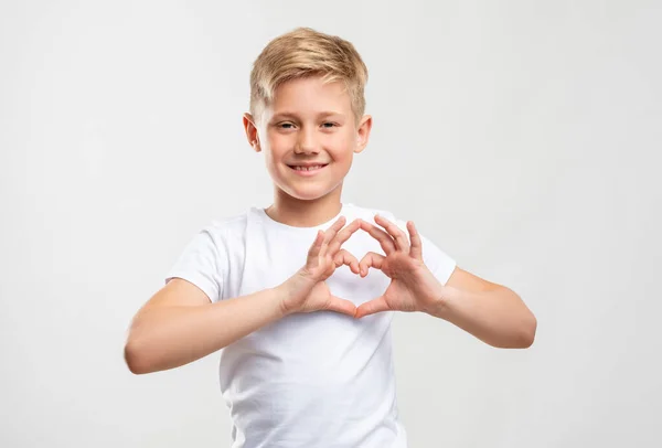 Láska znamení přátelské blond chlapec ukazující srdce gesto Stock Snímky
