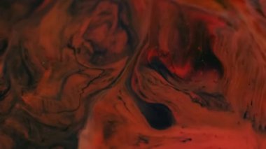Sıvıyı karıştır. Akış sanatı. Su mermeri emülsiyonunda bulanık turuncu pembe boya soyut koyu siyah arka planda yayılan mavi lekeler..