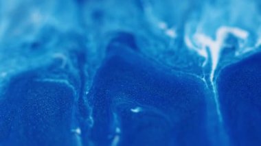 Mürekkep akıyor. Damla arkaplanı. Odaklanmamış mavi beyaz renk boya parıltılı su kabarcığı sıvı ıslak doku soyut diş minesi sanatı üzerinde akıyor..