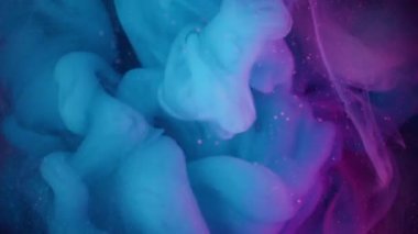 Puslu sanat patlaması. Renkli sis. Siyah arka planda mavi mor bir girdap var. Mürekkep karışımı parlayan parçacıklar odaklanmış sanat sıvısı.