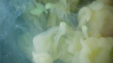 Su altı boyası. Haze girdabı. Soyut sıvıda sarı sisli akış mürekkebi. Siyah arkaplanda fantezi bulanık renk damlası karışımı.