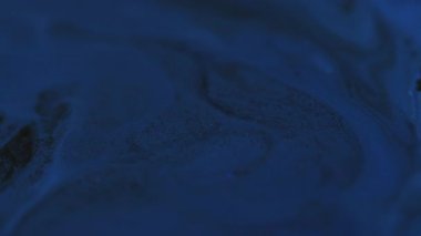 Mürekkep lekeleri. Karışım akışı. Odaklanamayan mavi renkli parlak su mermeri, soyut sanat üzerine hareket eden kimyasal dokuları kıvılcım saçar..