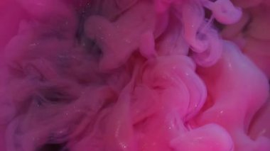 Sis sıvısı. Parıldayan dalga. Neon parlak boya sisi menekşe suyunda çözülüyor. Pembe parlak duman soyut bulanık arka plan üfleme.