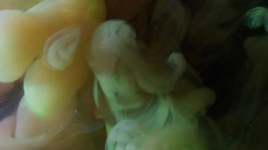 Buhar karışımı. Parıldayan sis. Parlak dumanlı boya patlaması siyah arka planda renk pigmentini karıştırıyor. Sarı yeşil soyut parıltı sihirli akışı.