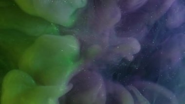Puslu sanat patlaması. Renkli sis. Siyah arka planda yeşil mor bir girdap var. Mürekkep karışımı titreşen parçacıklar çözünmüş sıvı.