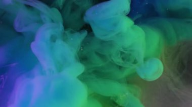 Haze yayıldı. Boya akışı. Mor arka planda mavi yeşil sıvı sis dalgası spreyi. Renkli neon rengi soyut pigment karışımı bulanık üfleme.