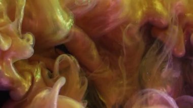 Duman patlaması. Işıl ışıl. Pembe sarı mürekkep atışı çözülüyor. Soyut bulanık siyah arkaplanda renkli parlak buhar üfleme karışımı.