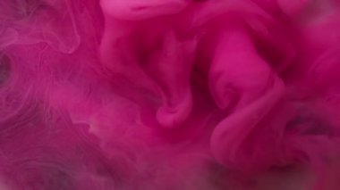 Duman dalgası. Mürekkebi karıştır. Bulanık pembe beyaz renk su sıçratır dalgalı sis dokusu soyut koyu siyah arkaplanda daireler çizer..