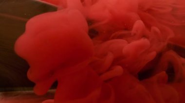 Dönen dokular. Mürekkep suyu. Soyut koyu siyah arka planda çözünmüş kırmızı renkli akrilik geometrik duman sıvısı.