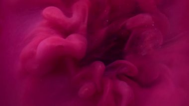 Bulut yayılıyor. Sis boyası. Odaklanmamış mor renkli sıvı harman dumanı yuvarlak sıçrıyor soyut koyu siyah arkaplanda daireler çiziyor.