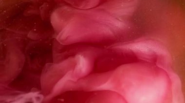 Bulut dumanı. Sıvı sıçraması. Bulanık pembe renk boya su girdap gibi dönen sis akrilik parçacıklar yaratıcı siyah soyutlama üzerinde sallanıyor.