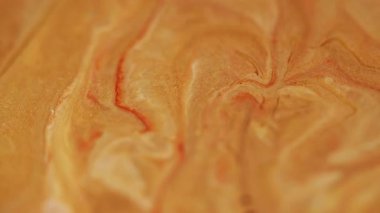 Altın sıçrama. Islak doku. Soyut sanat arka planında su akrilik karışım dalgasında akan bulanık sarı turuncu boya..