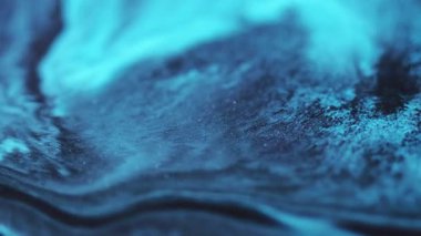 Glitter mix. Ink emulsion. Defocused blue color shimmering water chemical texture spreading on abstract art dark black background.