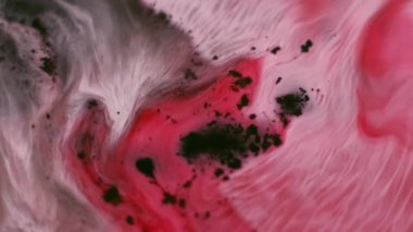 Mürekkep parçacıkları. Renk karışımı. Odaklanmamış pembe kırmızı su emülsiyon sıvısı dalgalanma lekeleri soyut sanat üzerine akan koyu siyah arkaplan.