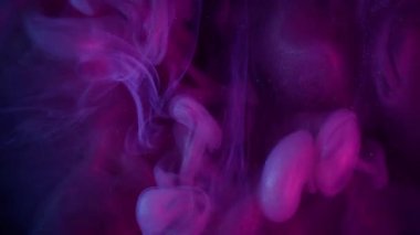 Sis sıvısı. Pigment dalgası. Neon mor mor boya suda çözünüyor. Siyah arkaplanda parlayan duman soyut odaklanmış karışım.