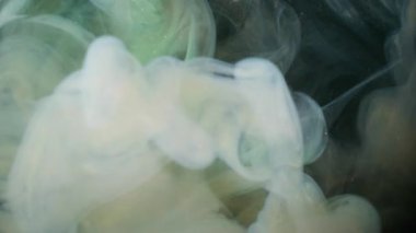 Buhar bulutu. Köpüklü sıvı. Siyah arka planda beyaz sarı duman spreyi fırtınası. Renkli sıvı boya soyut bulanıklık suya sıçrar.