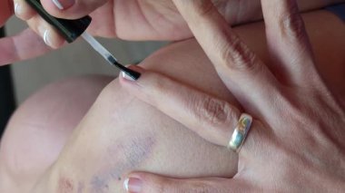 Siyah tırnak cilası uygulaması ile koyu diz çürüklerini gizlemek, kişisel bakım ve iyileştirme yaklaşımını ortaya çıkarmak,