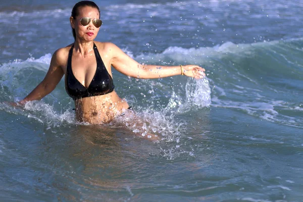 Woman with black bikini enjoy with wave on beach — Foto de Stock