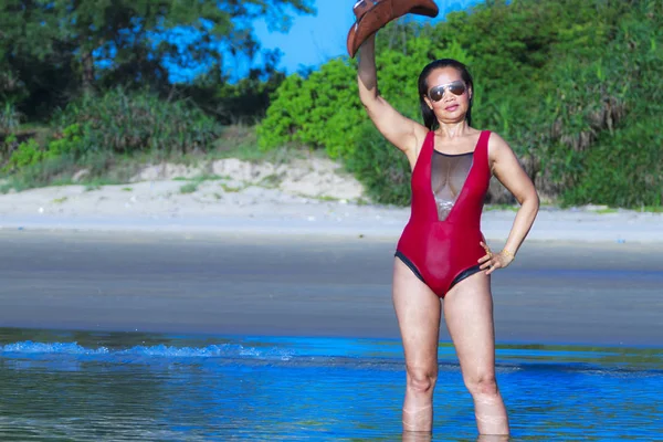 Woman bikini crimson with hat show beautiful on beach — Zdjęcie stockowe