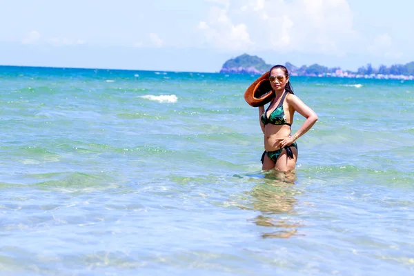 Woman with hat and bikini stand in sea water — Stok fotoğraf