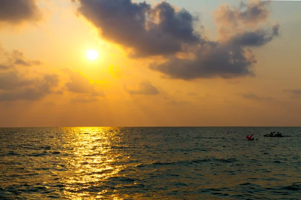 Koh Chang Tayland 'daki Issız plajda gün batımı ve küçük tekne silueti.