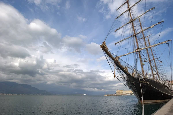 ancient black sailing ship anchored in the harbor,