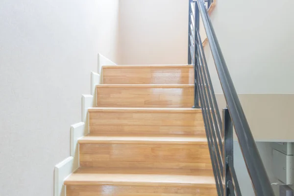 Staircase, wooden floor and black iron rail.