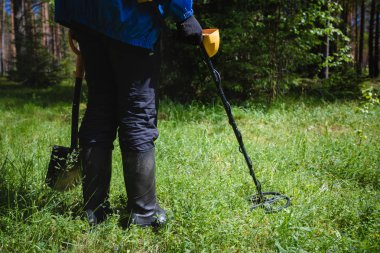 ormanda bir metal detektörü olan bir adam