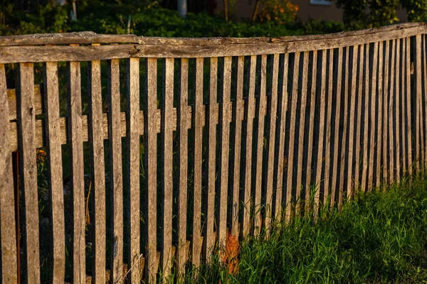 Soare scăzut pe un gard de lemn și iarbă — Fotografie, imagine de stoc