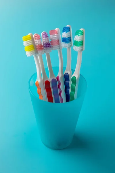 Toothbrushes on a blue background in a blue glass — Stock Photo, Image