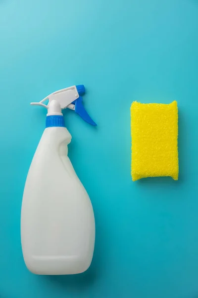 Mavi bir arka plan üzerine bir sünger ile beyaz bir şişede temizlik maddesi — Stok fotoğraf