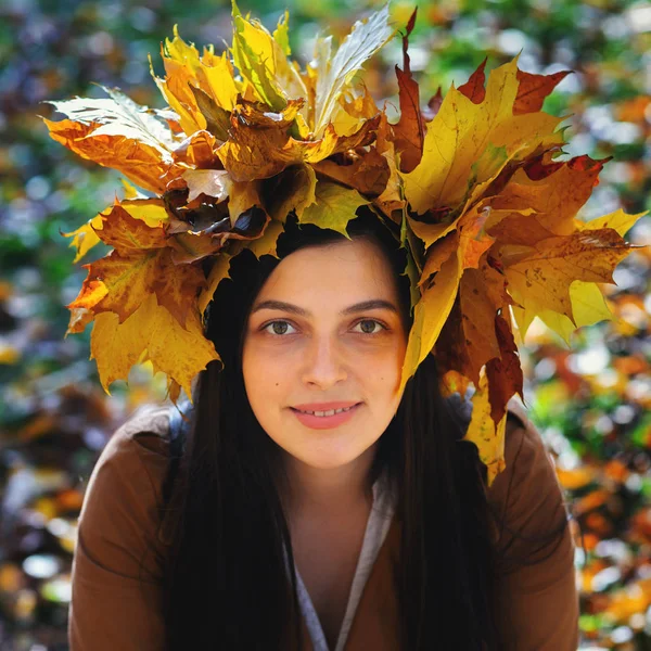 户外生活方式近距离描绘了迷人的年轻女子, 穿着秋叶花环。走在秋天的公园。枫叶的花环 — 图库照片
