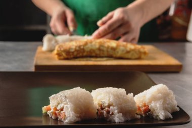 elinde bir bıçak pirinç yassı bir rulo keser. closeup ahşap oyun tahtası.
