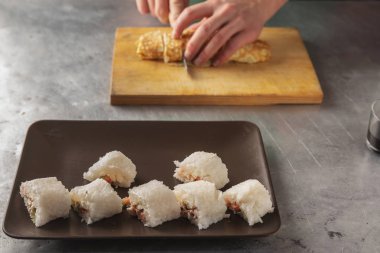 elinde bir bıçak pirinç yassı bir rulo keser. closeup ahşap oyun tahtası.