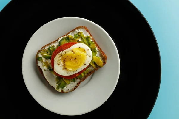 sandwich with avocado salad on white plate. Avocado and mayonnaise with egg and paprika.