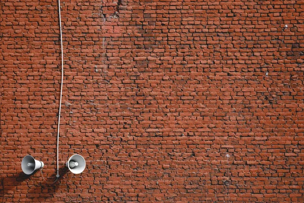 Alto-falantes brancos em um fundo de parede de tijolo vermelho — Fotografia de Stock