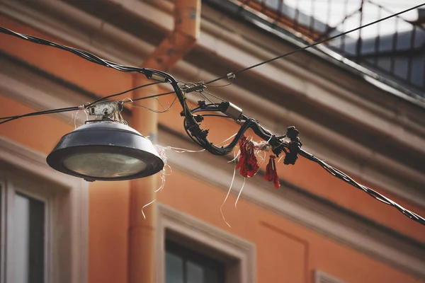 Una lámpara de calle en cables aéreos y el edificio en el fondo. Vista desde abajo . —  Fotos de Stock