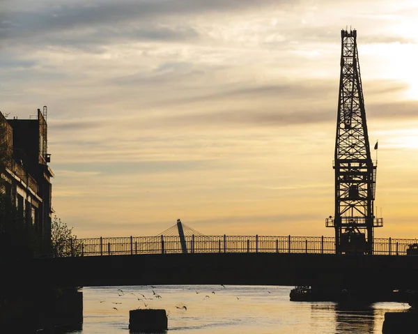 silhouette of a construction crane at sunset sky evening