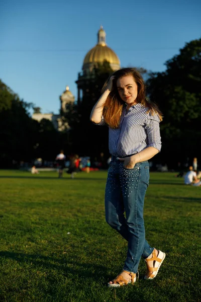 Портрет милой девушки в городе. девушка на лужайке в городском парке — стоковое фото
